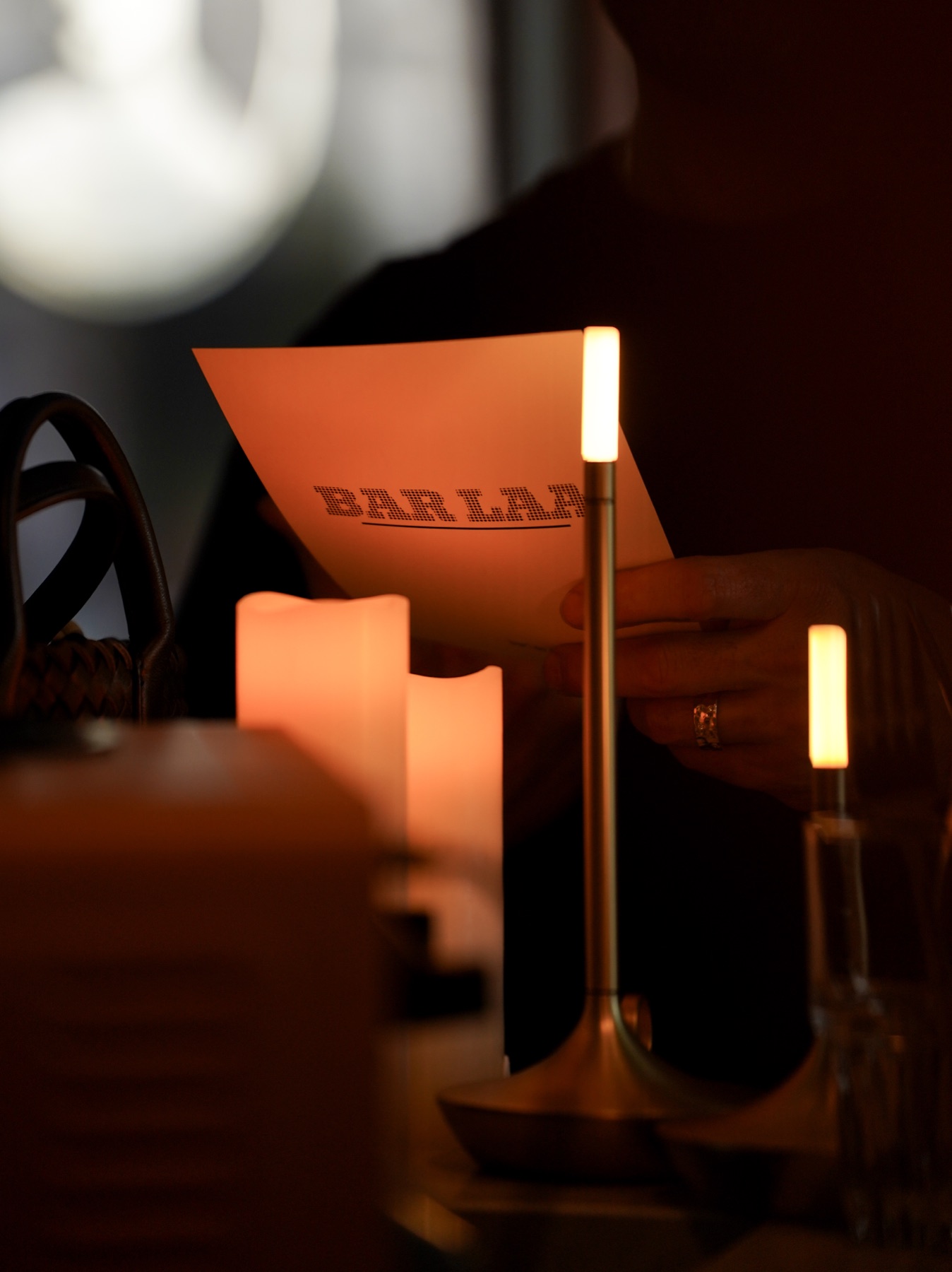Guests gathered by candlelight at Bar Laa, the room glowing with warmth